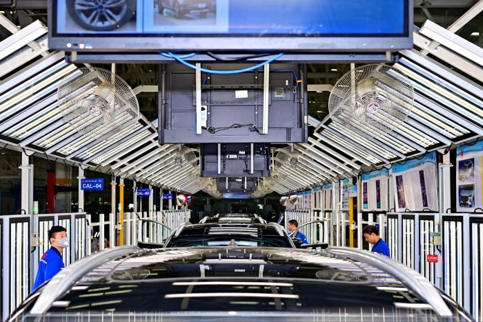 Employees work on an electric vehicle assembly line at the Jiangling Motors factory